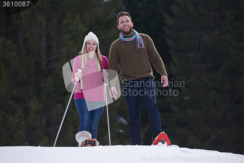 Image of couple having fun and walking in snow shoes