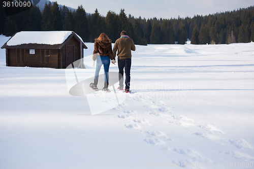 Image of couple having fun and walking in snow shoes