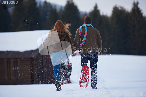 Image of couple having fun and walking in snow shoes