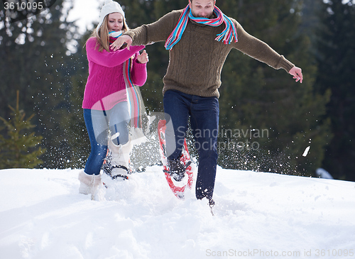 Image of couple having fun and walking in snow shoes
