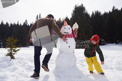 Image of happy family building snowman