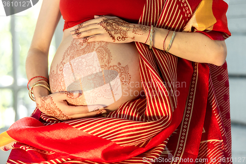 Image of The pregnant woman belly with henna tattoo