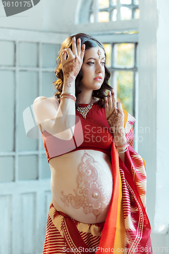 Image of The pregnant woman belly with henna tattoo