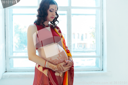 Image of The pregnant woman belly with henna tattoo