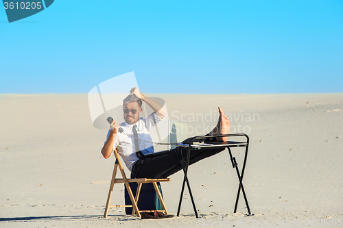 Image of Businessman using  laptop in a desert