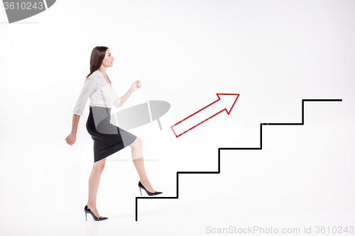 Image of Young businesswoman walking up on stairs