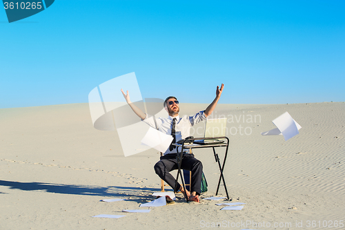 Image of Businessman using  laptop in a desert