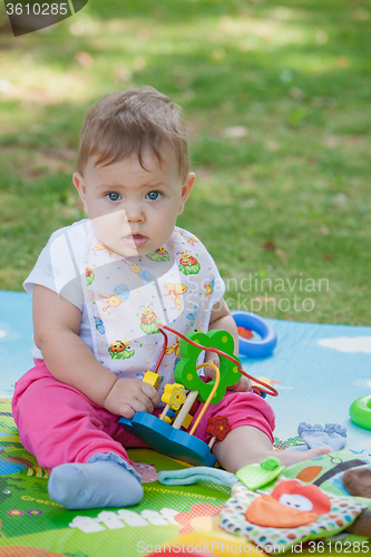 Image of Baby, less than a year old   playing with  toy 