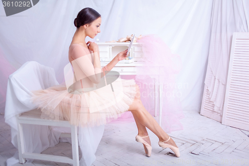 Image of Professional ballet dancer looking in the mirror on pink