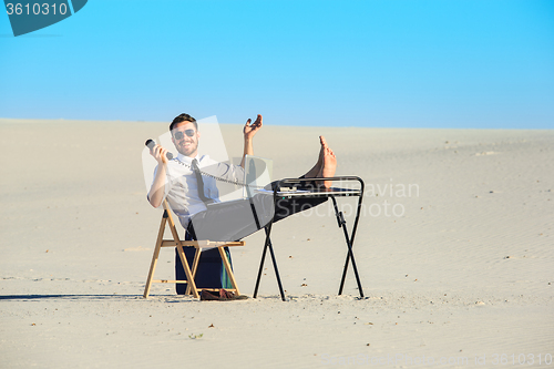 Image of Businessman using  laptop in a desert