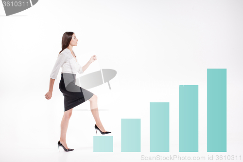 Image of Young businesswoman walking up on stairs
