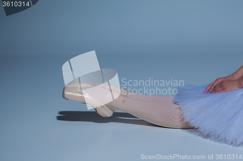 Image of legs of the ballerina in ballet  pointes on blue background