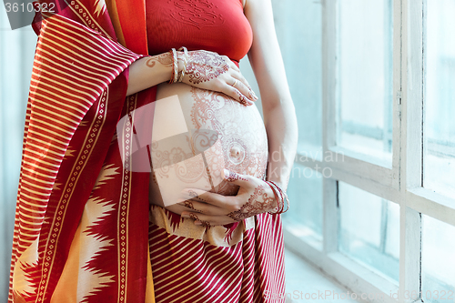 Image of The pregnant woman belly with henna tattoo