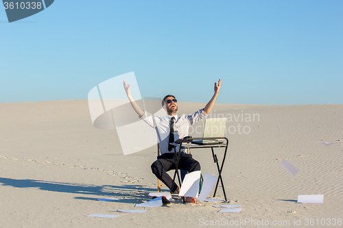 Image of Businessman using  laptop in a desert