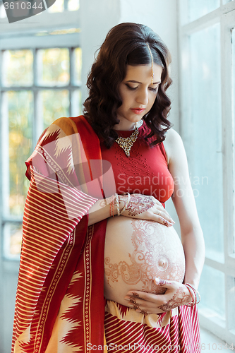 Image of The pregnant woman belly with henna tattoo