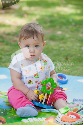 Image of Baby, less than a year old   playing with  toy 