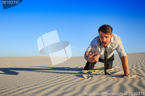 Image of Poor signal. businessman searching for mobile phone signal in desert