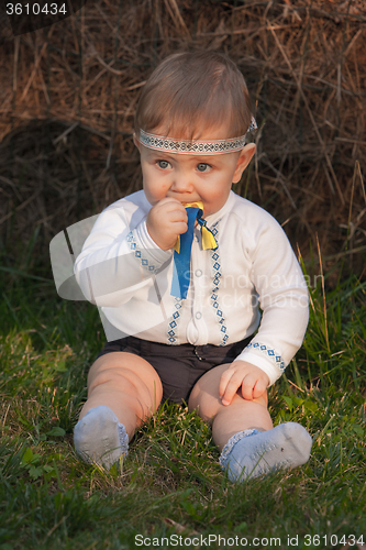Image of Baby girl, less than a year old on green grass 