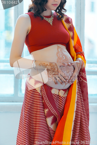 Image of The pregnant woman belly with henna tattoo
