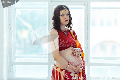 Image of The pregnant woman belly with henna tattoo