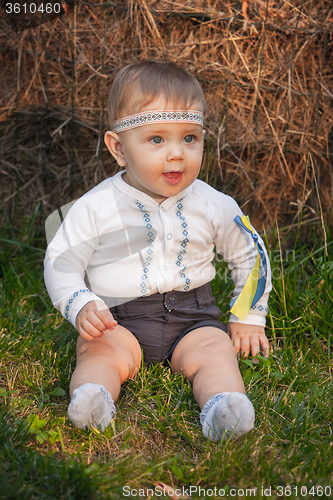 Image of Baby girl, less than a year old on green grass 