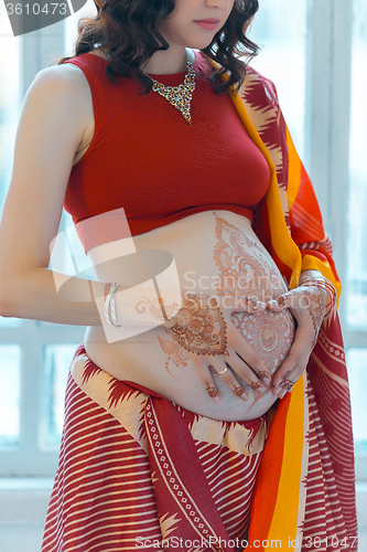 Image of The pregnant woman belly with henna tattoo