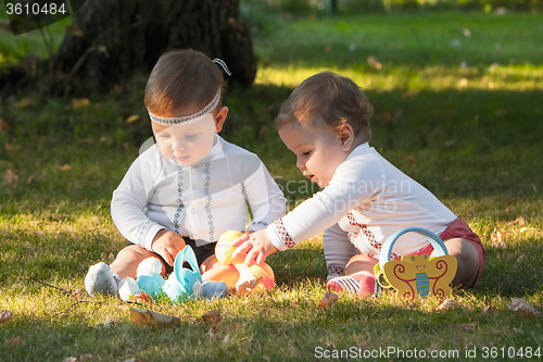 Image of Babys, less than a year old, playing with  toys 