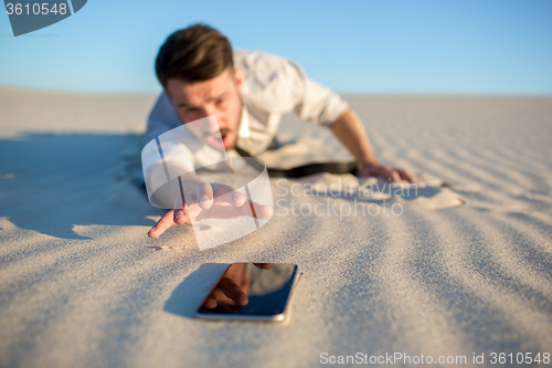 Image of Poor signal. businessman searching for mobile phone signal in desert