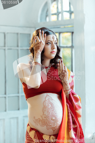 Image of The pregnant woman belly with henna tattoo