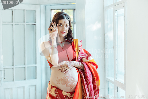 Image of The pregnant woman belly with henna tattoo