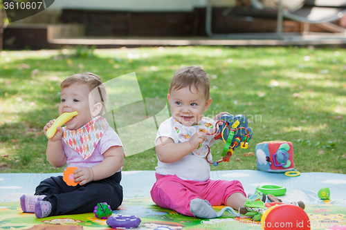 Image of Babys, less than a year old, playing with  toys 