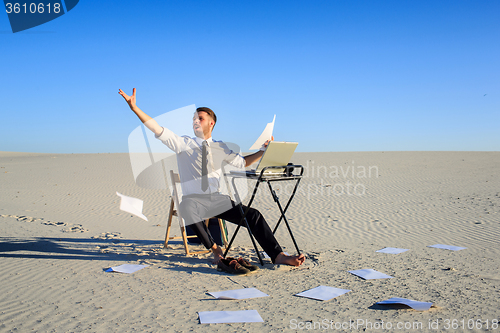 Image of Businessman using  laptop in a desert