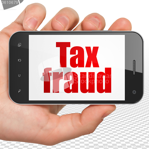 Image of Law concept: Hand Holding Smartphone with Tax Fraud on display