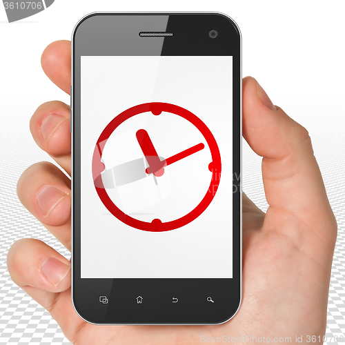 Image of Time concept: Hand Holding Smartphone with Clock on display