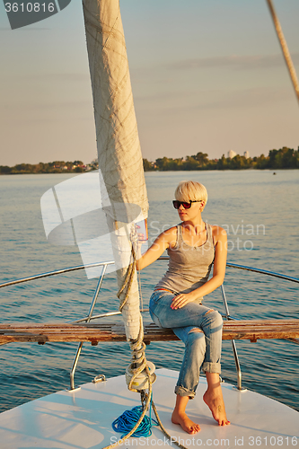 Image of Pretty young female tourist makes selfie on yacht