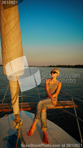 Image of Woman traveling by boat at sunset
