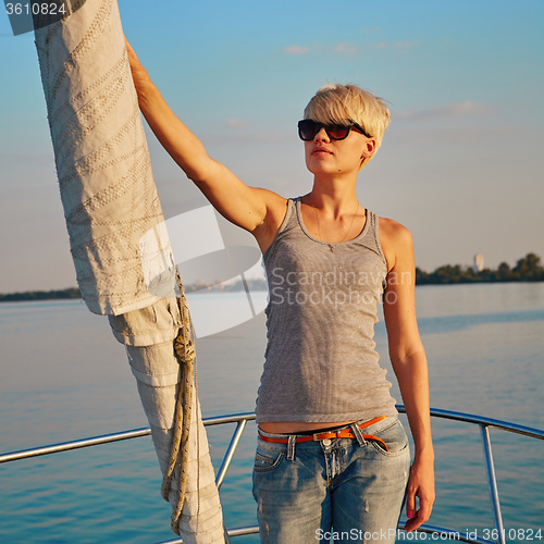 Image of Woman traveling by boat at sunset