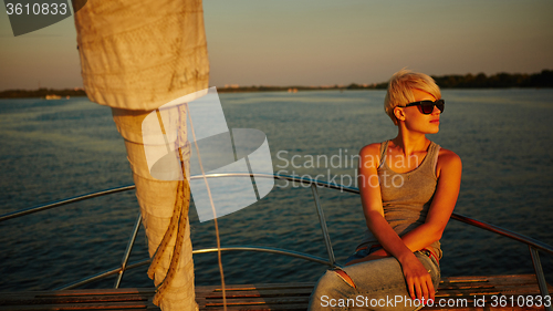 Image of Woman traveling by boat at sunset