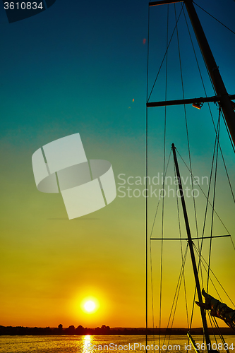 Image of Sail boat gliding in sea at sunset