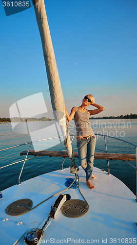 Image of Woman traveling by boat at sunset
