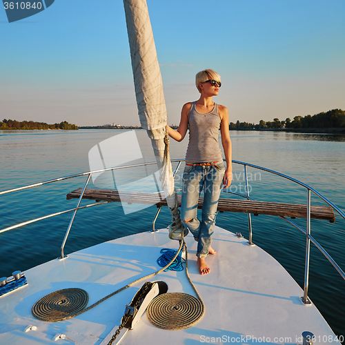 Image of Woman traveling by boat at sunset