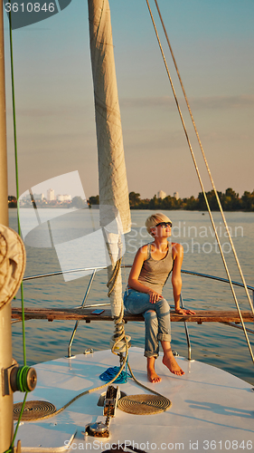 Image of Woman traveling by boat at sunset