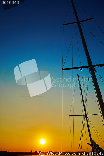 Image of Sail boat gliding in sea at sunset