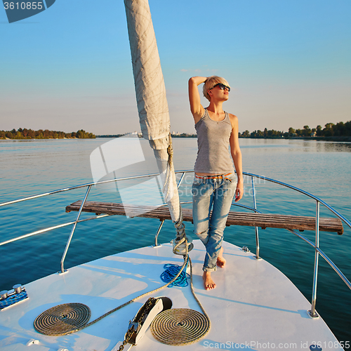 Image of Woman traveling by boat at sunset