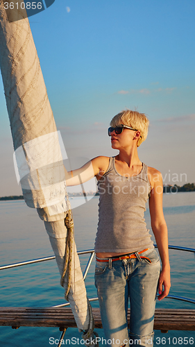 Image of Woman traveling by boat at sunset