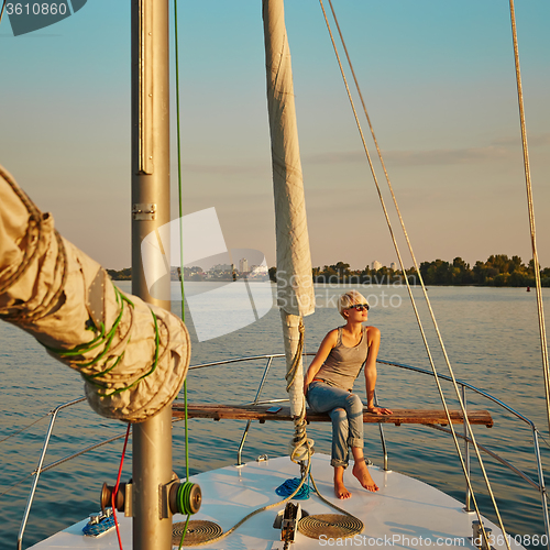 Image of Woman traveling by boat at sunset