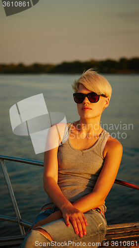 Image of Woman traveling by boat at sunset