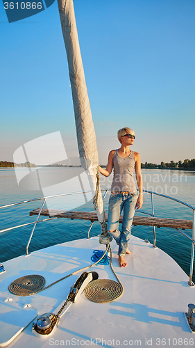 Image of Woman traveling by boat at sunset