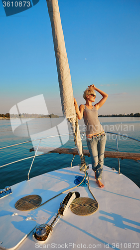 Image of Woman traveling by boat at sunset