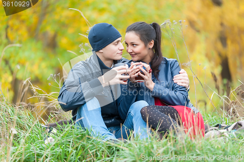 Image of Young romantic couple relaxes on autumn nature